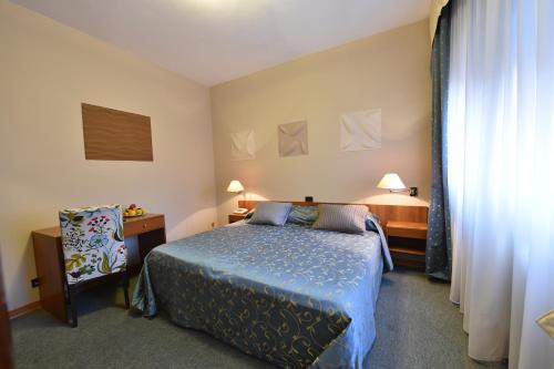 伊塞奥AMBRA HOTEL - The only central lakeside hotel in Iseo的一间卧室配有一张床、一张桌子和一把椅子