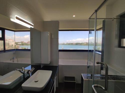 蒙巴萨English Point Residence Beach Apartments Mombasa的浴室配有盥洗盆、浴缸和盥洗盆