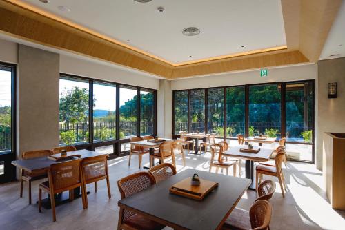 车城长钰温泉饭店 Samiling Resort 的餐厅设有桌椅和大窗户。