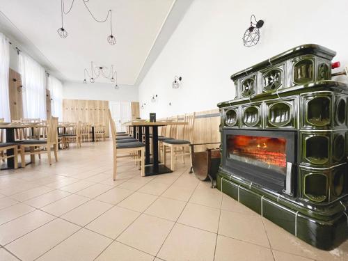 Kožlí u Orlíka伍诺瓦库膳食公寓的一间设有餐厅的房间的大壁炉