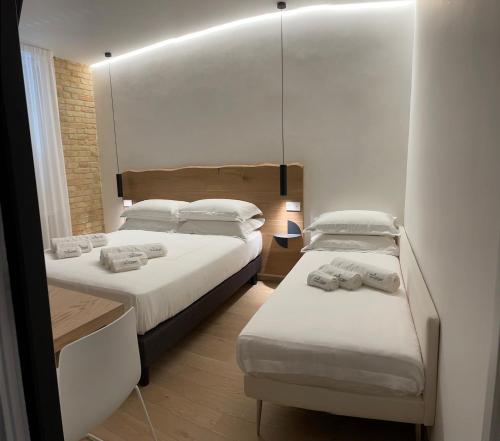 西维尔诺瓦·马尔凯Civitaloft Luxury Rooms的一间卧室配有两张床和镜子
