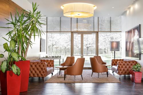 莱奥本Asia Hotel & Spa Leoben的大堂设有椅子、桌子和大窗户