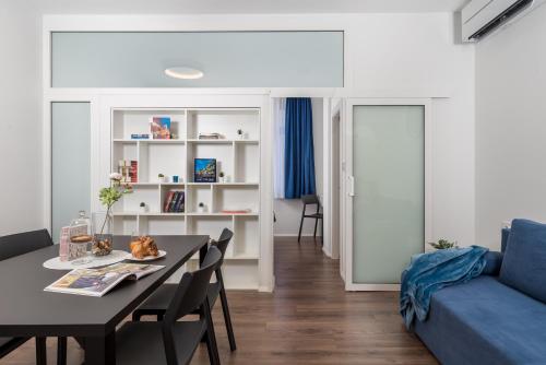 里耶卡Apartmani Artqart Rijeka的客厅配有桌子和蓝色沙发