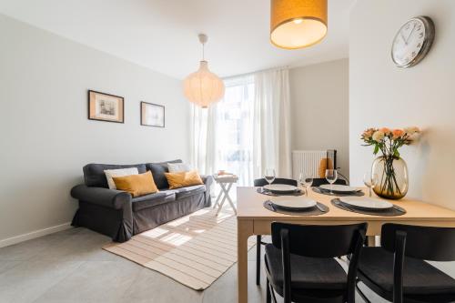 詹塔尔Flatbook Apartamenty - Jantar Bursztynowe Osiedle的客厅配有桌子和沙发