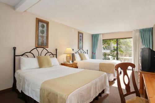 奥欣赛德赛德滨海套房 - 海滨酒店的酒店客房设有两张床和电视。