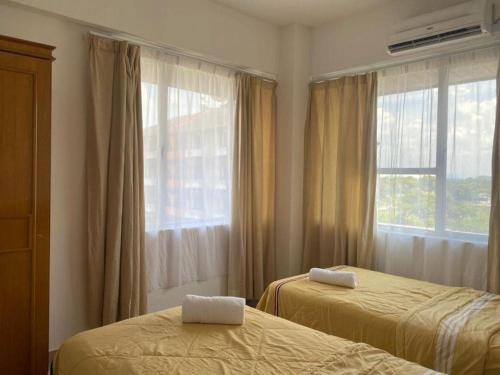 甘榜甘马挽D’lina pelangi的一间卧室设有两张床和窗户。