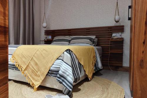 达累斯萨拉姆Makazi Yetu的一间卧室配有一张大床和木制床头板