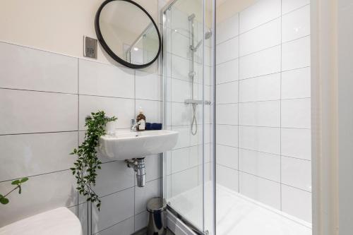 布雷得佛Stylish 2 bed apartment close to city的一间带水槽、淋浴和镜子的浴室