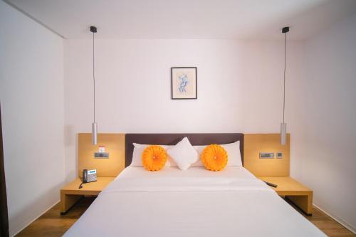 阿布贾SV Chrome的一间卧室配有一张带橙色枕头的大床
