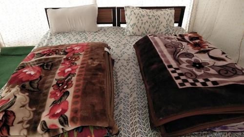 Sir Bhum Chun加哈小山徒步旅行露营旅馆的床上配有被子和枕头