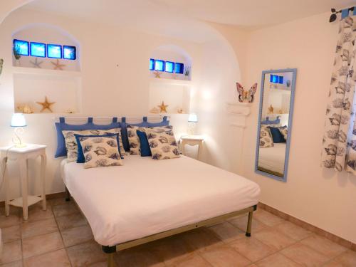 MaladrosciaAppartamento in villa panoramica Maladroxia的一间卧室配有一张带蓝色枕头和镜子的床
