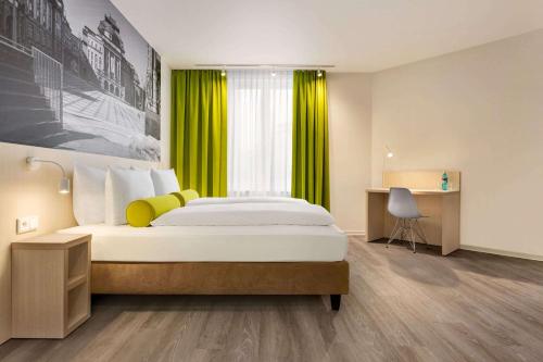 开姆尼茨Super 8 by Wyndham Chemnitz的一间卧室配有一张黄色窗帘的大床