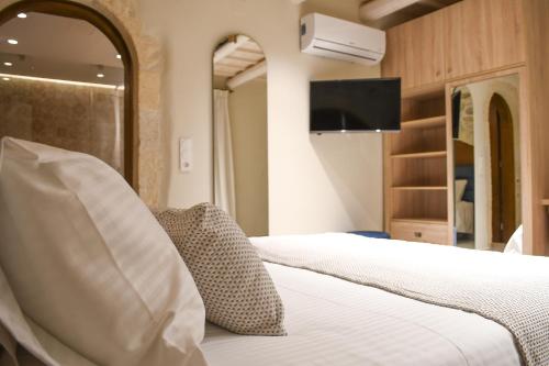 罗希姆诺Philikon Luxury Suites的一间酒店客房,配有一张床和一台电视