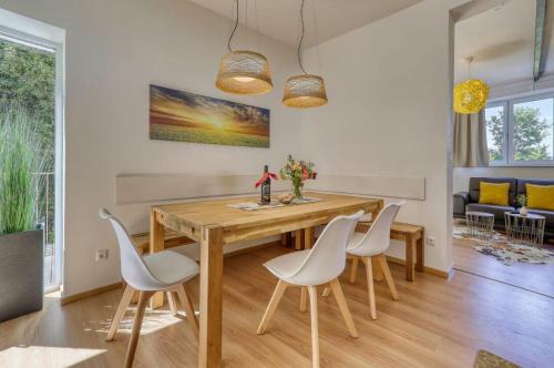 德拉塞尔斯里德Das Bachhaus的一间带木桌和白色椅子的用餐室