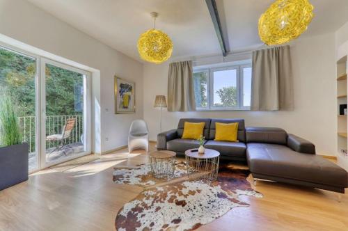 德拉塞尔斯里德Das Bachhaus的客厅配有黑色真皮沙发和黄色枕头。