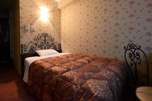 东京樱花芙蓉青山酒店的壁纸客房内的一间卧室配有一张床
