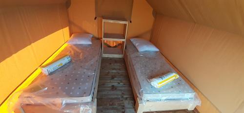 巴涅斯Tente Cabane du Camping Hautoreille的小房间,箱内有两张床