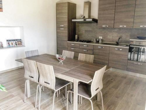 皮蒂利亚诺La Casa all'Oliveto的厨房配有木制餐桌和椅子