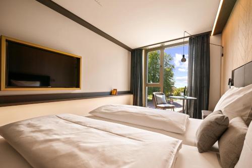 腓特烈港Lukullum的酒店客房设有两张床和一台平面电视。