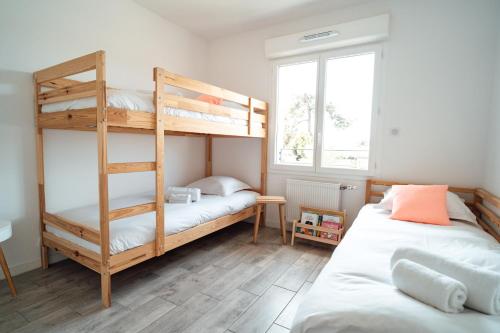 拉特斯特德布赫SEAHORSE - Spacieux Appartement proche du port de la Teste的一间卧室设有两张双层床和一扇窗户。