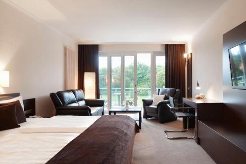海德柏林诺迪卡酒店的酒店客房,配有床和椅子