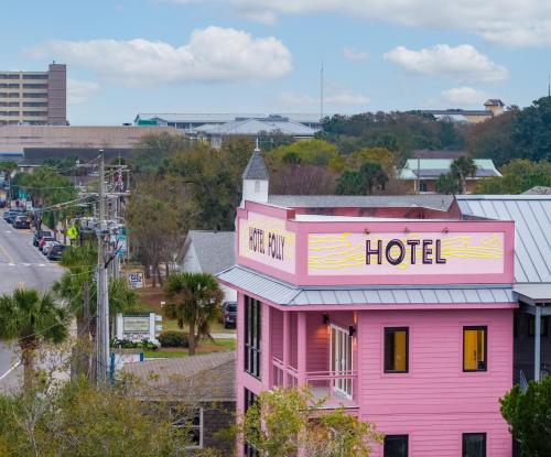 富丽海滩Hotel Folly with Marsh and Sunset Views的粉红色的建筑,上面有酒店标志