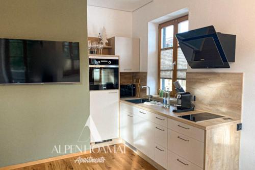 加尔米施-帕滕基兴Alpenhoamat Apartments的厨房配有水槽和炉灶 顶部烤箱