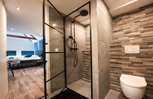 阿尔克马尔阿尔克马尔家庭酒店的一间带卫生间和淋浴的浴室以及一间卧室