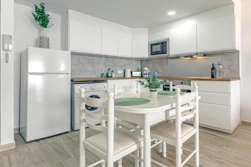 圣地亚哥港Ocean View Suite with beach private access的厨房配有白色桌子和白色冰箱。