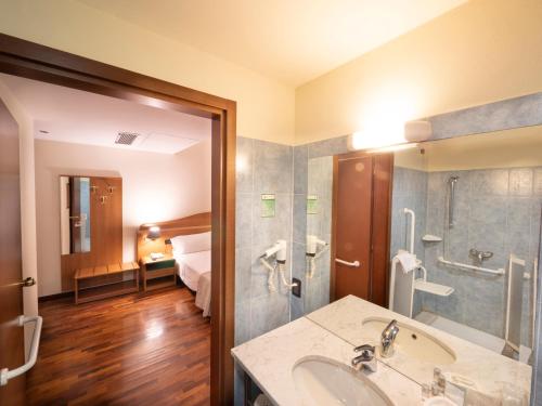 费拉拉德埃斯特伊尔杜卡酒店的一间带水槽的浴室和一间带床的房间