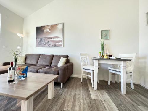 格洛米茨ZUM LEUCHTTURM Wellness-Appartement APPARTO Grömitz的客厅配有沙发和桌子
