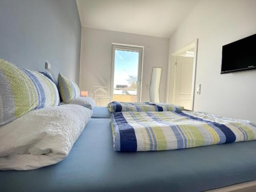 格洛米茨ZUM LEUCHTTURM Wellness-Appartement APPARTO Grömitz的一间卧室配有蓝色床上的两个枕头