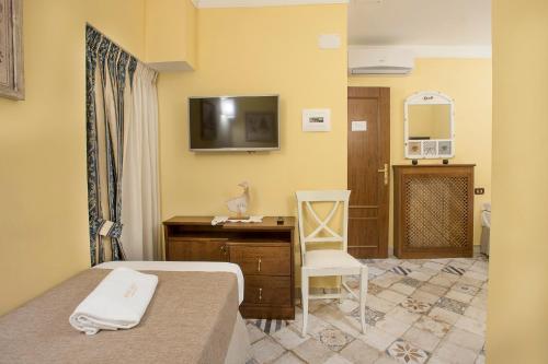那不勒斯德潘丹斯住宿加早餐旅馆的酒店客房配有一张床、一张书桌和一台电视。