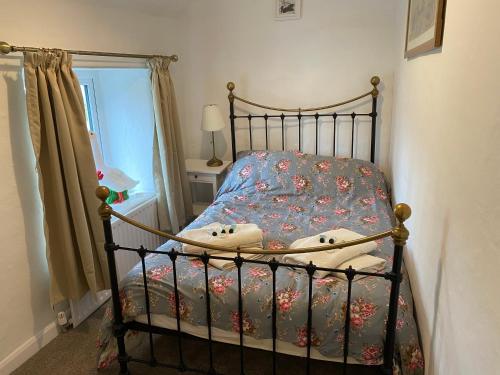 泰德斯韦尔Primrose cottage的小卧室配有一张带鲜花床罩的床
