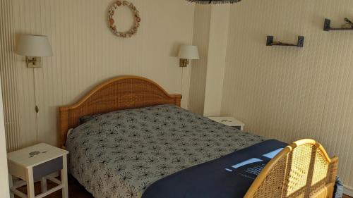 敦刻尔克Rêve Bleu的一间卧室配有一张带两张桌子和两盏灯的床。