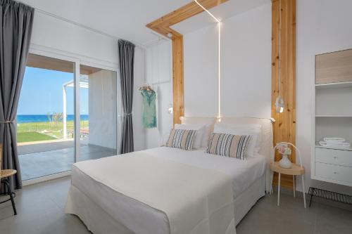 KamirosNiva Kamiros Apartments的卧室设有白色床,享有海景