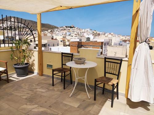 埃尔莫波利斯Fiera Guesthouse的设有一个配有桌椅并享有美景的阳台。