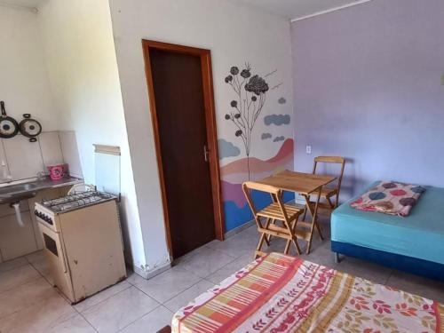 伊比科阿拉Pousada Serra Aquarela - Mini casas的客房设有厨房、桌子和床。