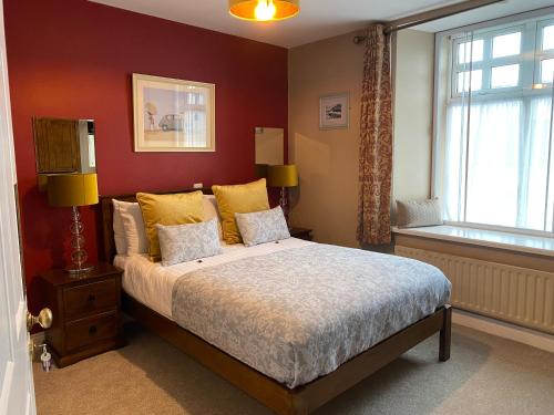 丁格尔灯笼排屋住宿加早餐旅馆的一间卧室配有一张带黄色枕头的床和一扇窗户