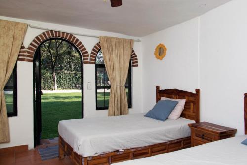 ChiconcuacQuinta Taboo的一间卧室设有两张床和两个窗户。