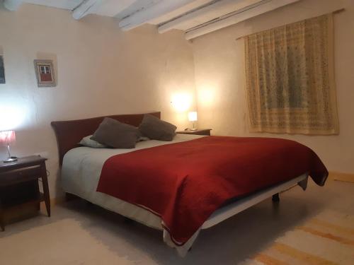 La PresaBonita Casa Rural en la Sierra de Aracena的一间卧室配有一张带红色毯子的大床