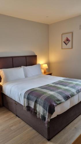 因奇Inch Beach Cottages的一间卧室配有一张大床,床上有毯子