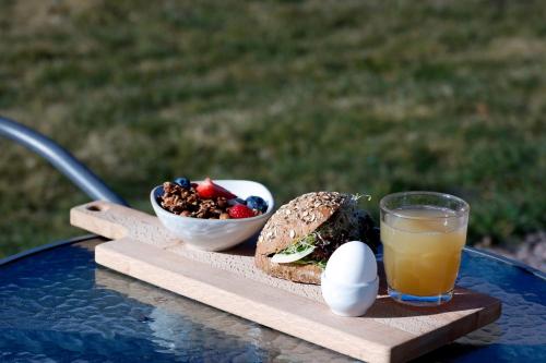 恩厄尔霍尔姆Enkegården Gårdshotell的三明治、鸡蛋、一碗水果和饮料