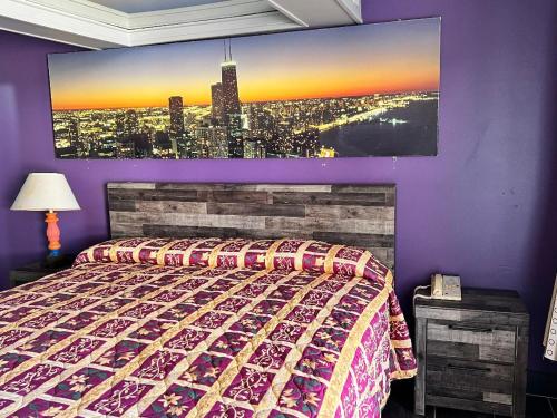 芝加哥迈阿密套房酒店的卧室配有一张床,墙上挂有绘画作品
