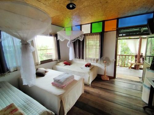 Ban Kho SaiMetha Country View Homestay Singburi的一间带两张床的卧室和一间带窗户的房间
