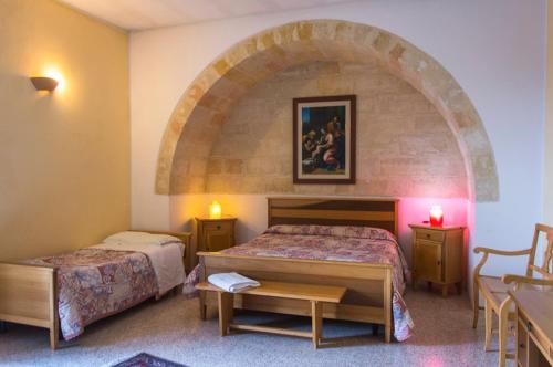 SupersanoCasale Sombrino的一间酒店客房,设有两张床和一个拱门