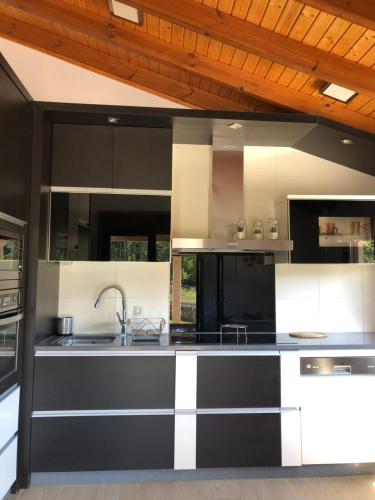 贡多马尔Pedra Moura Casa Rural的厨房配有黑白橱柜和水槽