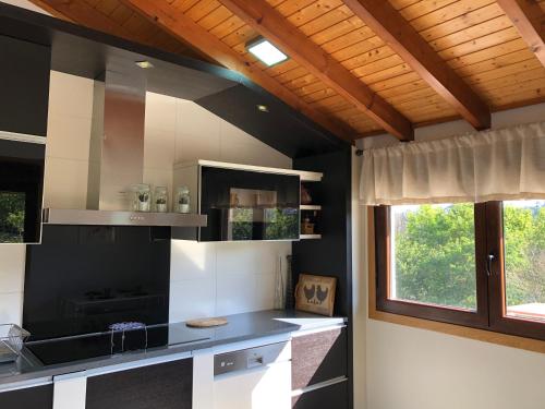 贡多马尔Pedra Moura Casa Rural的厨房设有黑白柜台和窗户。