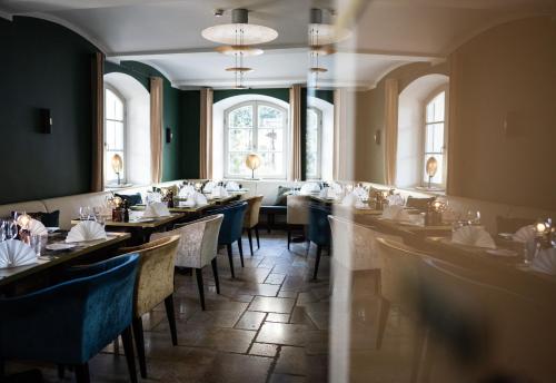 泰根塞路易特鲍尔德海滨酒店的用餐室设有桌椅和窗户。