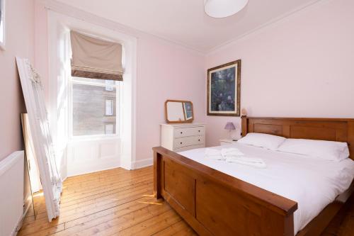 爱丁堡JOIVY Gorgeous 1-bed flat with a shared garden的卧室设有一张白色大床和一扇窗户。